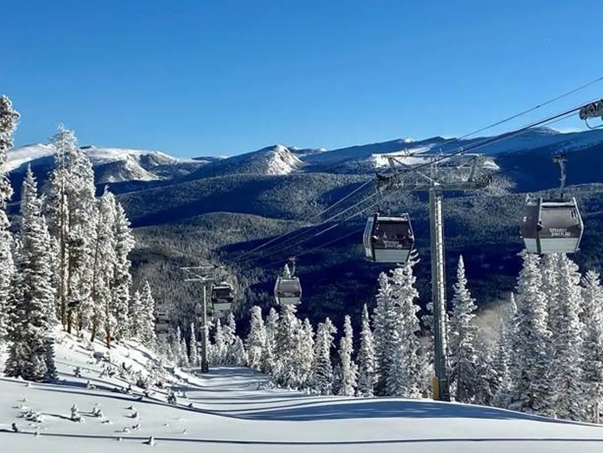 A stunning exterior scene showing a ski lift ascending snowy slopes, with majestic mountains in the background. The image captures the adventure and natural beauty of Winter Park, emphasizing easy access to the resort’s winter sports and year-round mountain activities.